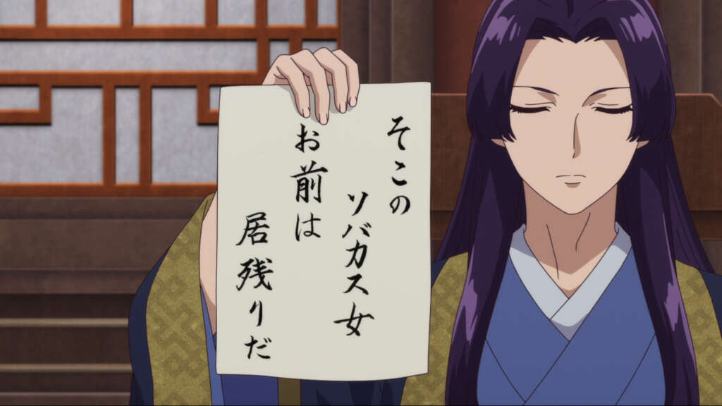 Jinshi hält einen Zettel in der Hand mit japanischen Schriftzeichen drauf.